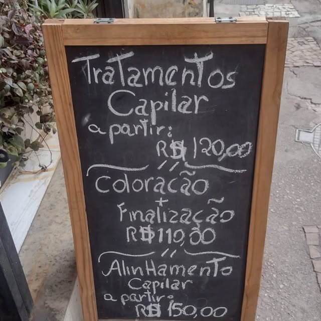 Quadro com tabela de tratamentos capilares na entrada do salão
